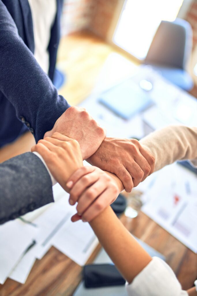 group of people holding each other's wrist as togetherness